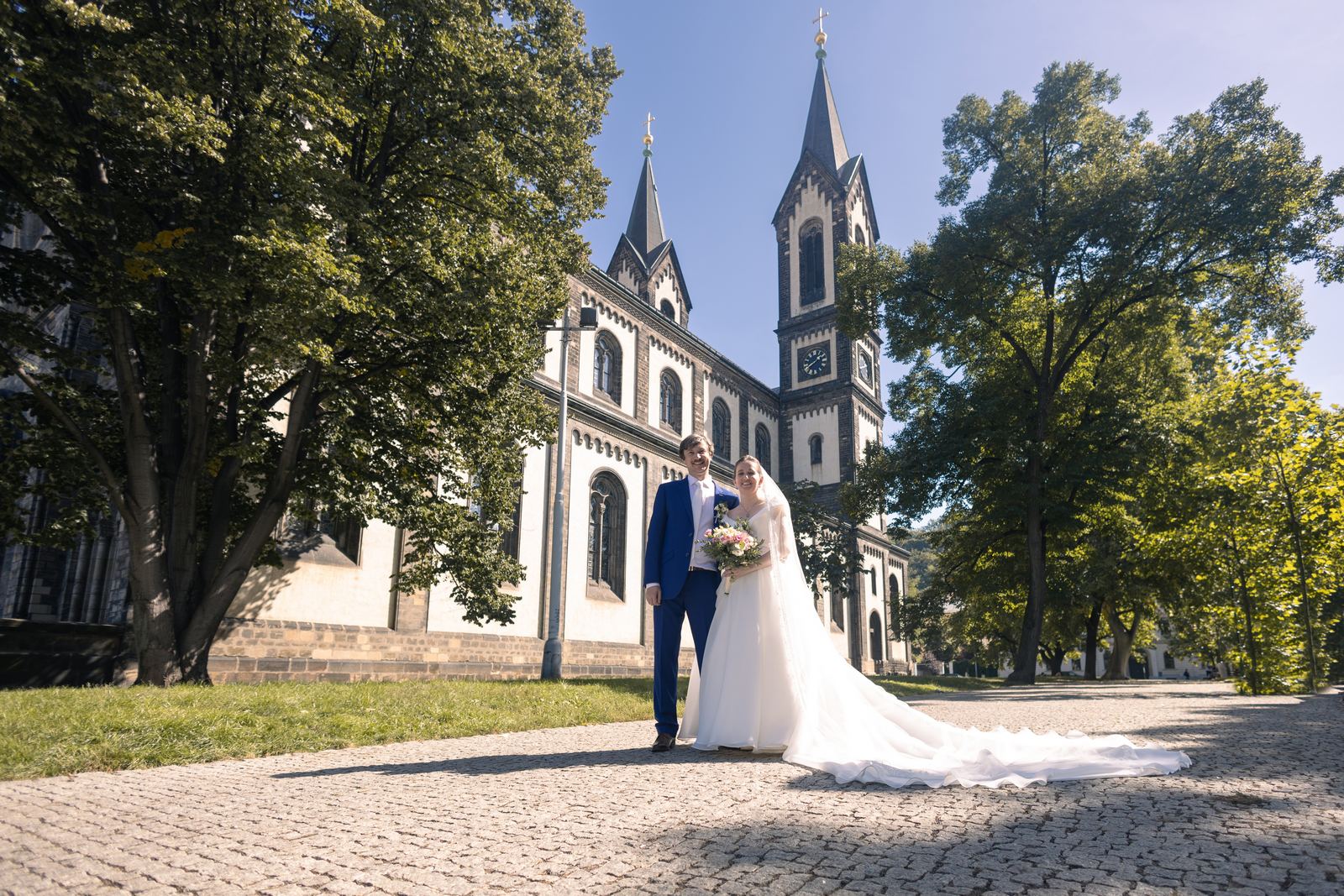 Svatební fotky Praha - ženich s nevěstou před kostelem