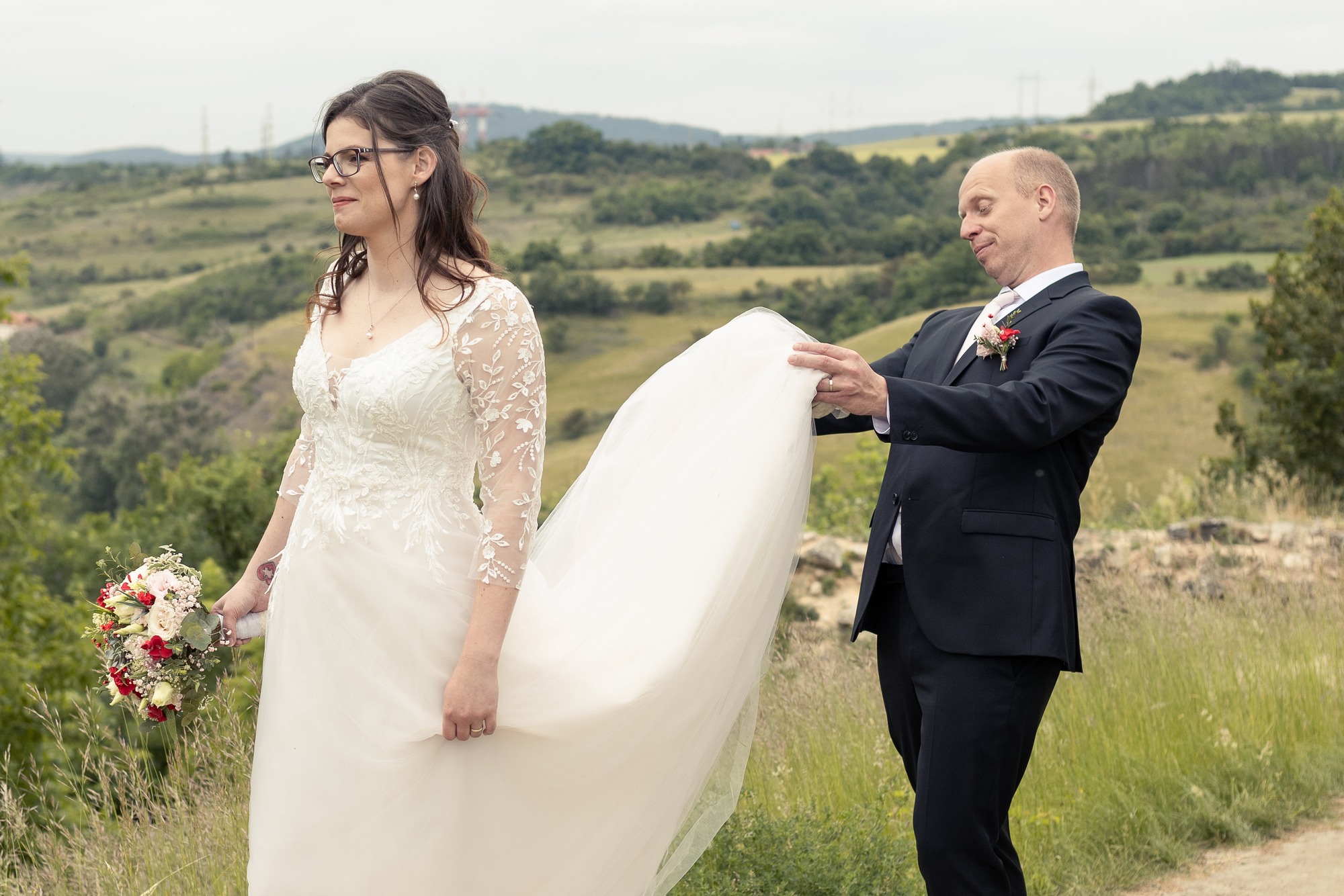 Svatba v Tetíně u Berouna - ženich se dívá nevěstě pod šaty