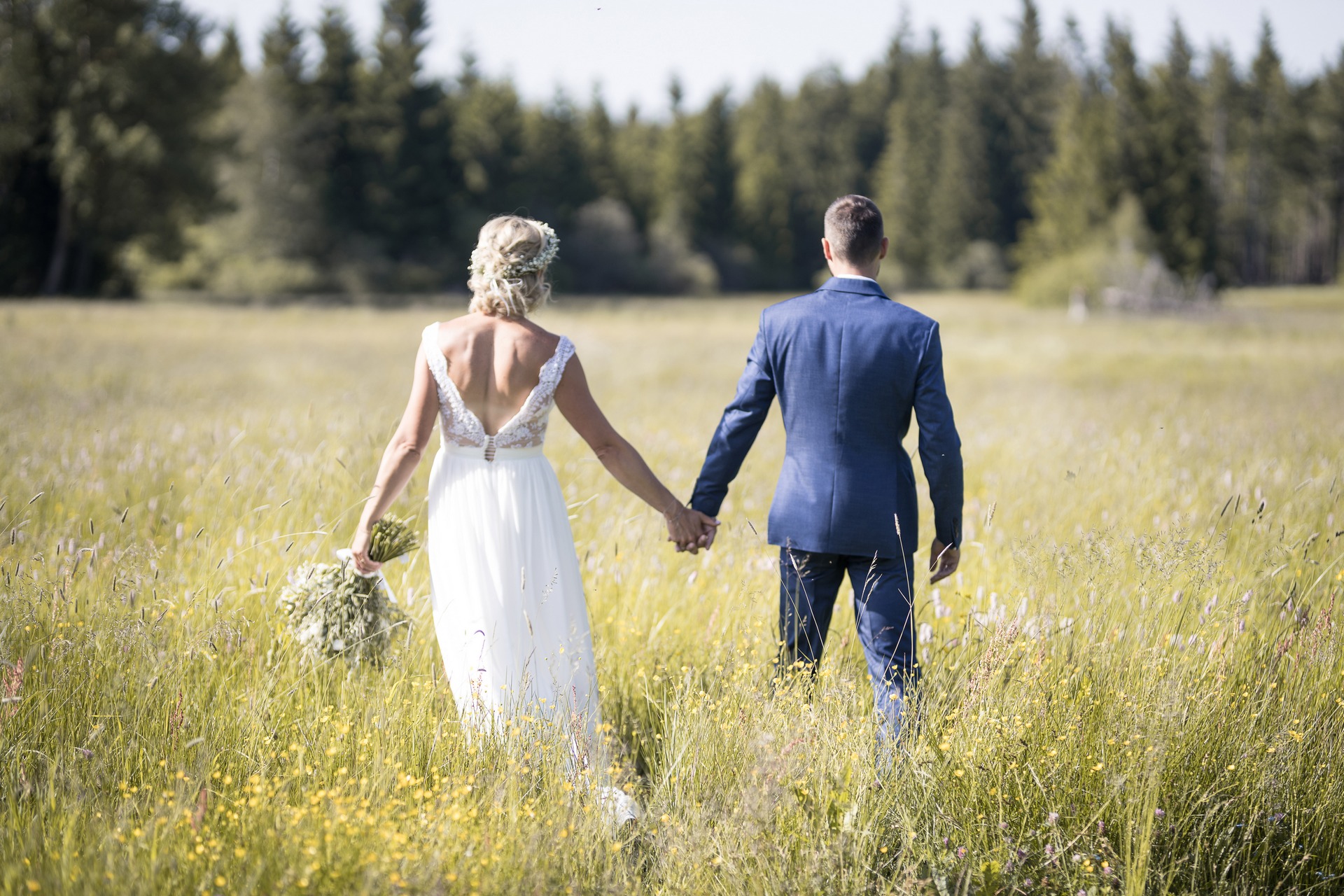 Svatba na Zadově (Churáňov, Šumava) - ženich a nevěsta společně kráčí loukou